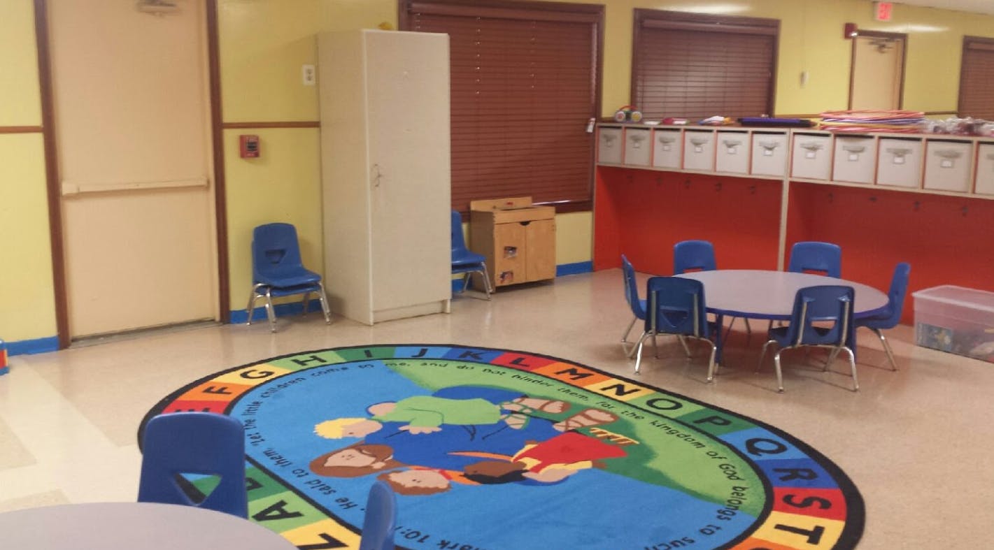 Classroom with a round rug, small table, and chairs