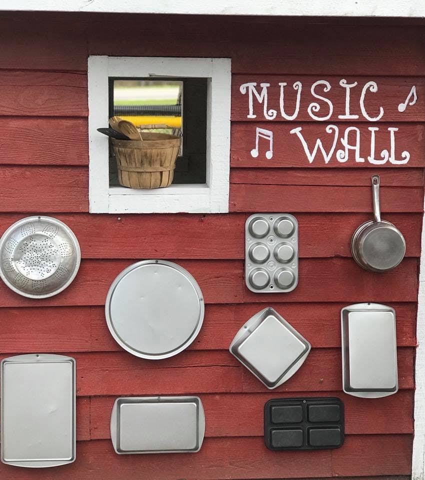 Baking pans and kitchen items on a red wall with "MUSIC WALL" text