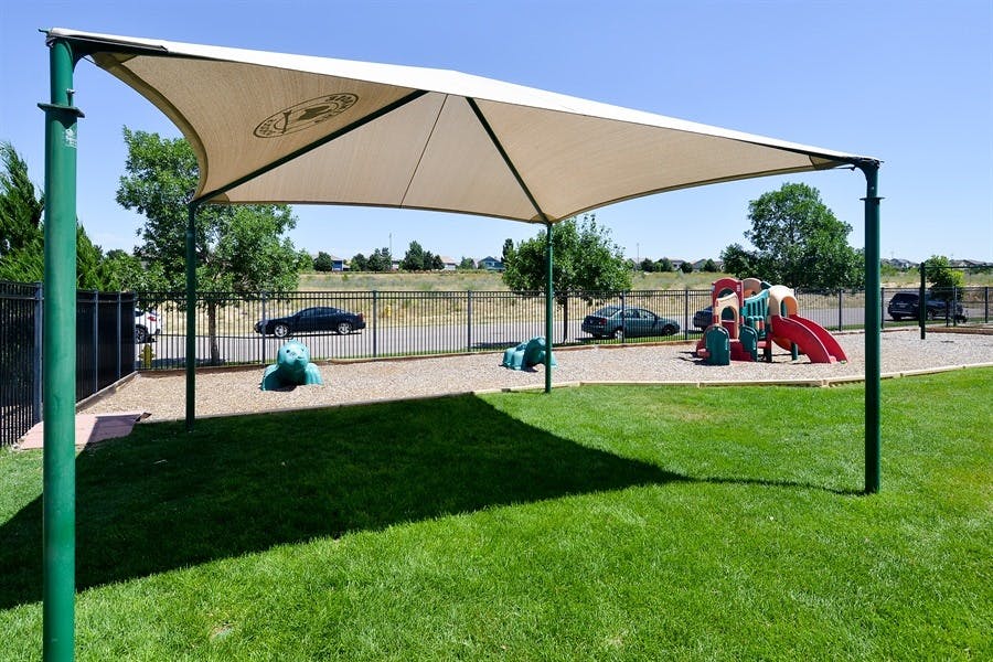 Playground with a large shade structure over a grassy area