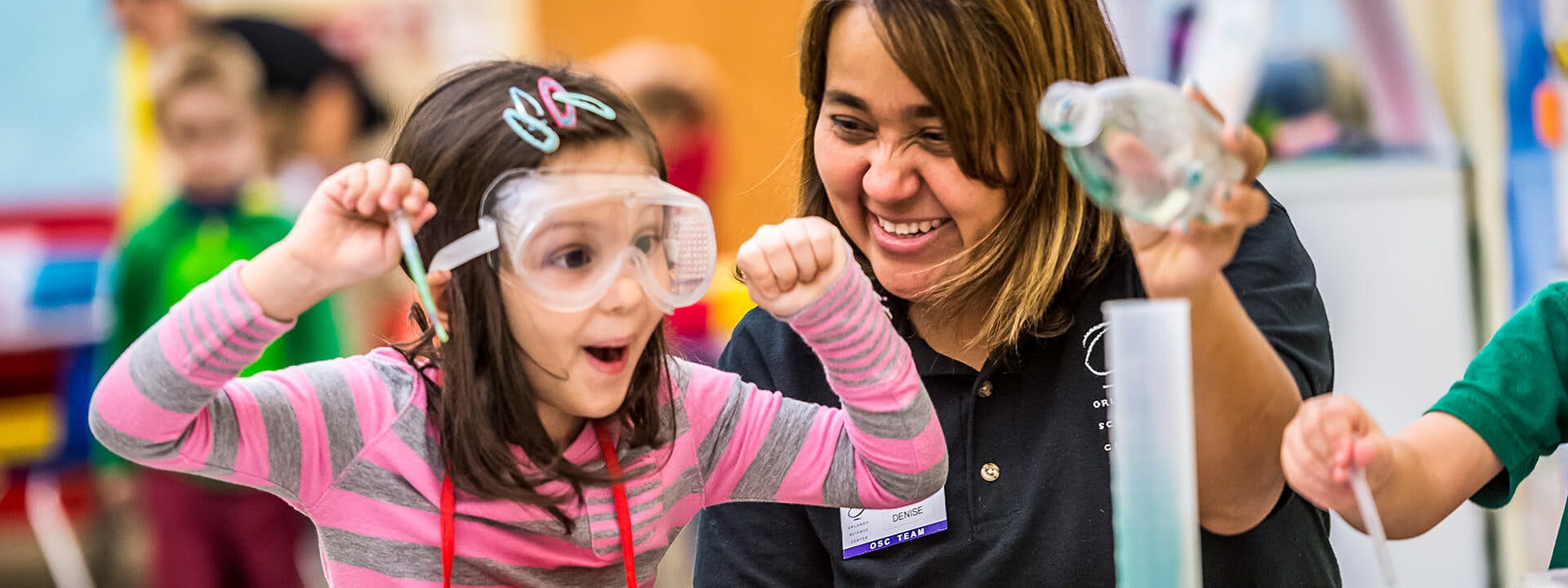 Adult and child in safety goggles doing a science experiment