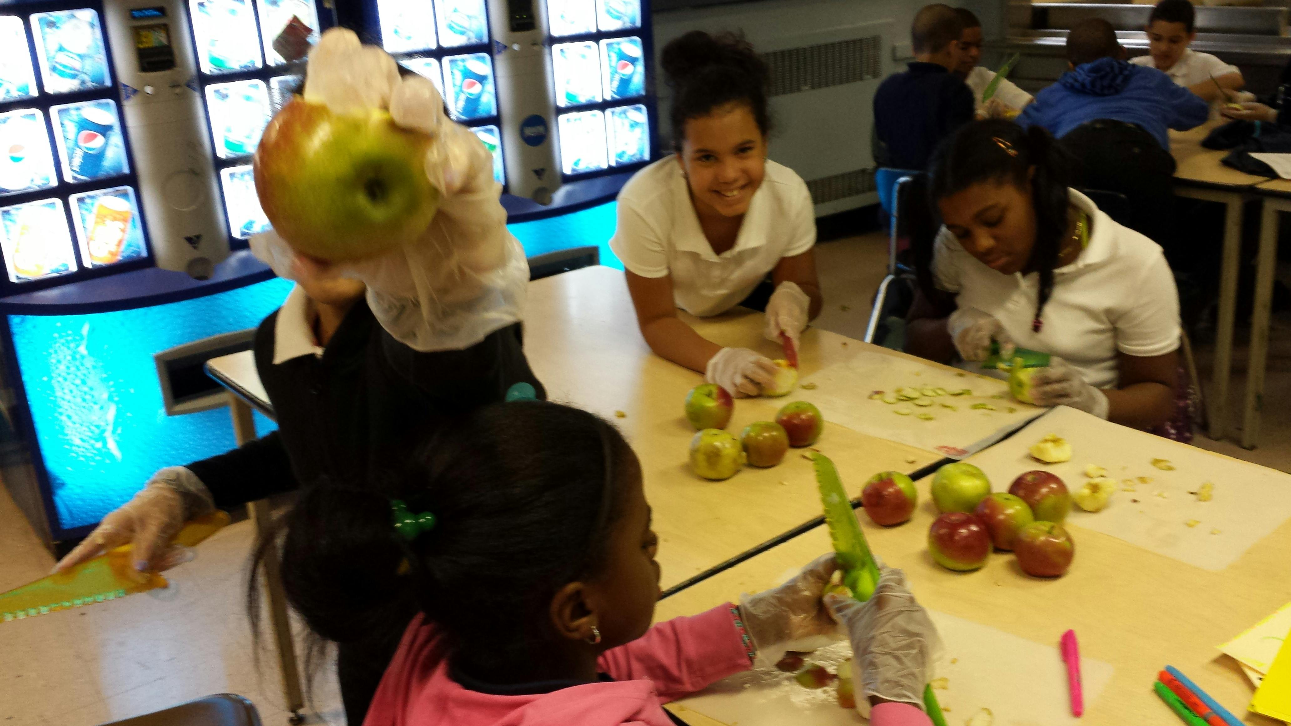 People and children peeling apples at a table