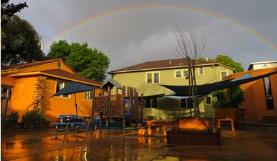 Rainbow over buildings and a playground