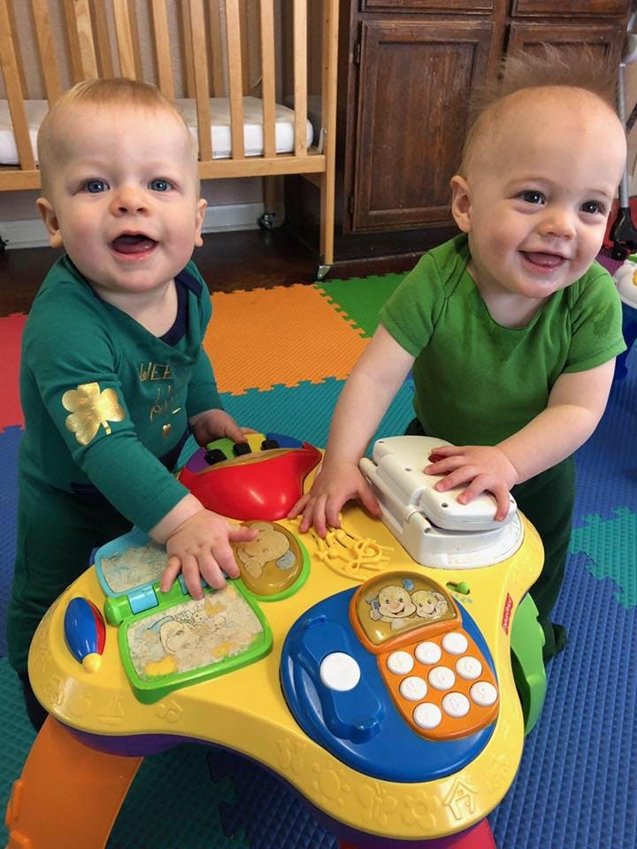 Two children playing with a colorful activity table