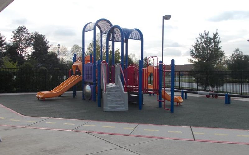 Colorful empty playground with multiple slides and climbing structures