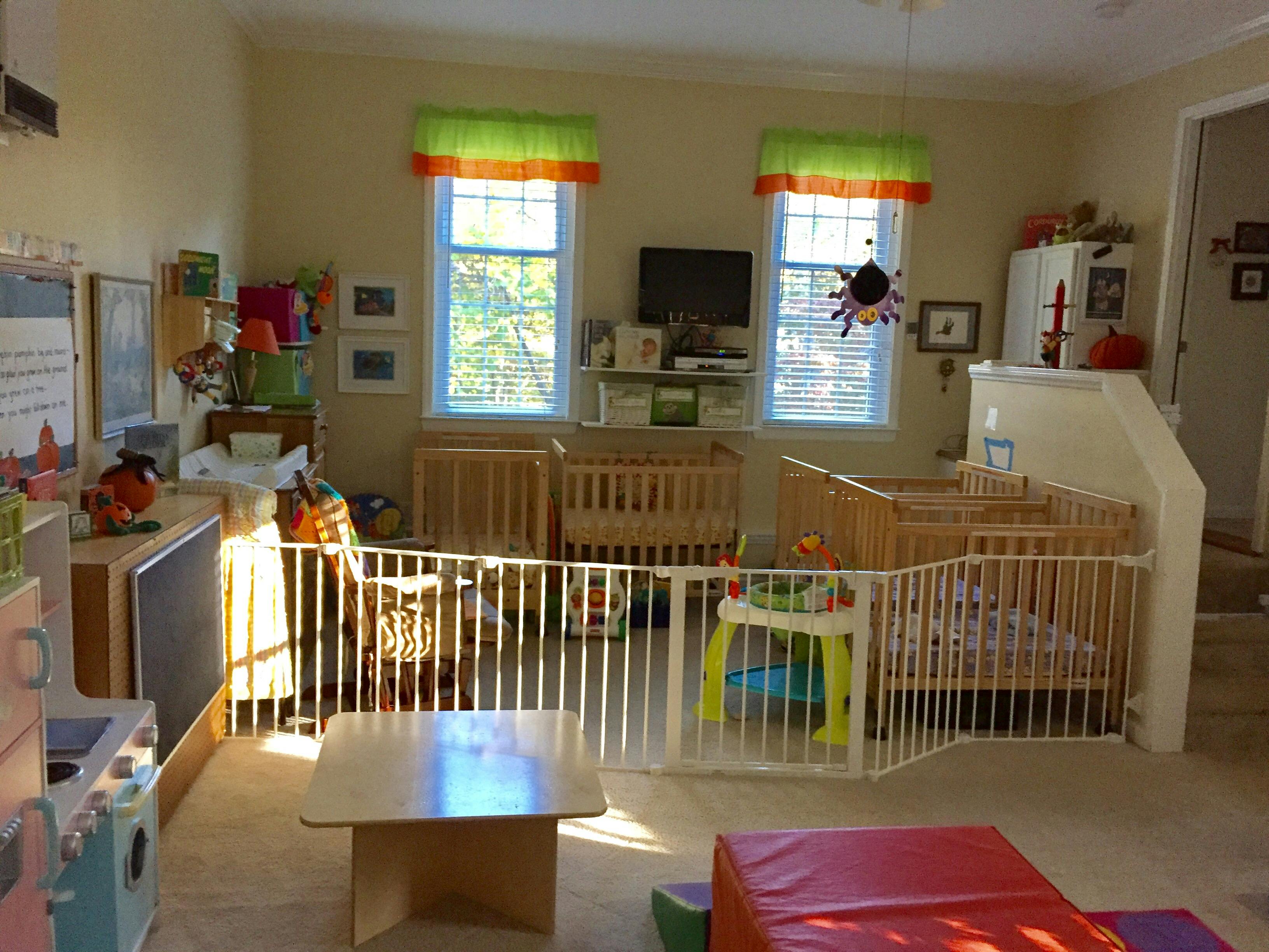 Nursery room with multiple cribs and a playpen