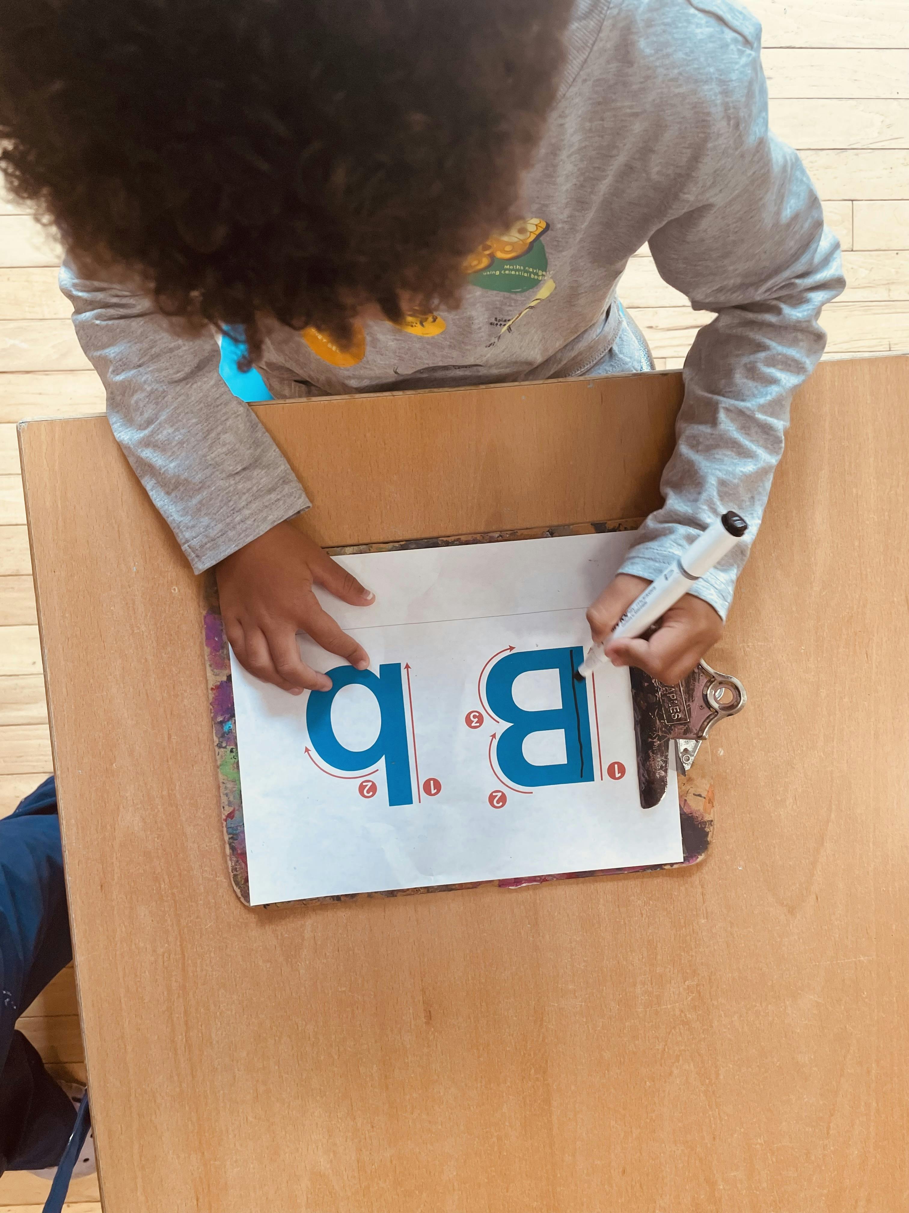 Child practicing writing the letter B on a worksheet