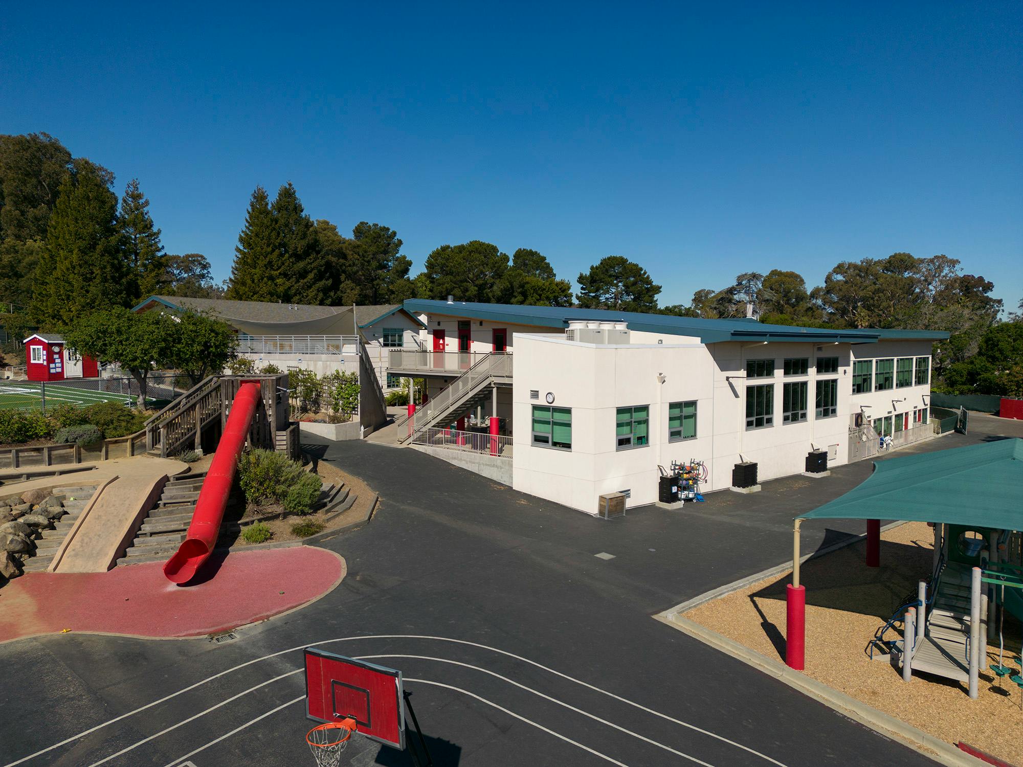 School building with playground and red slide