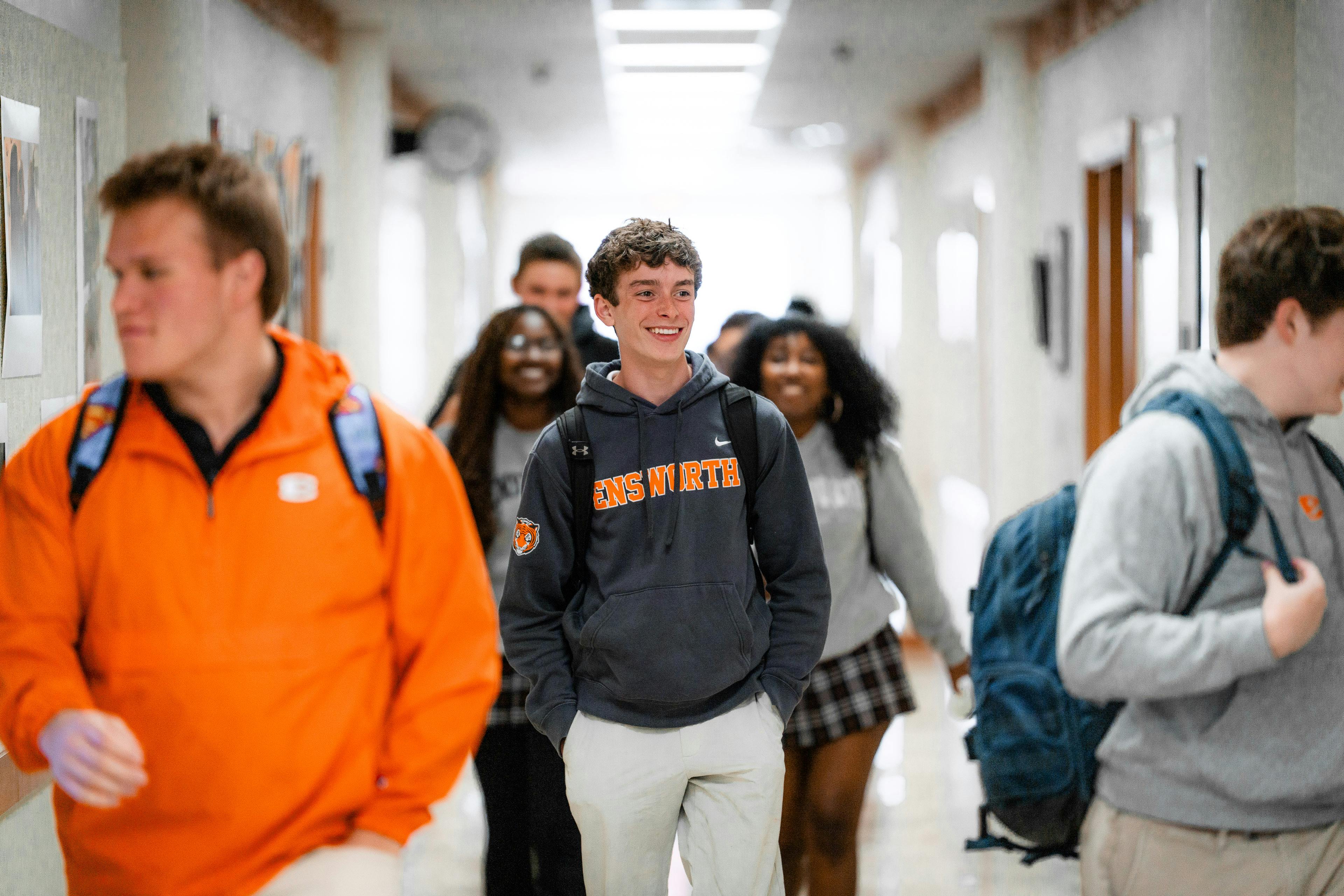 Group of students walking through a school hallway
