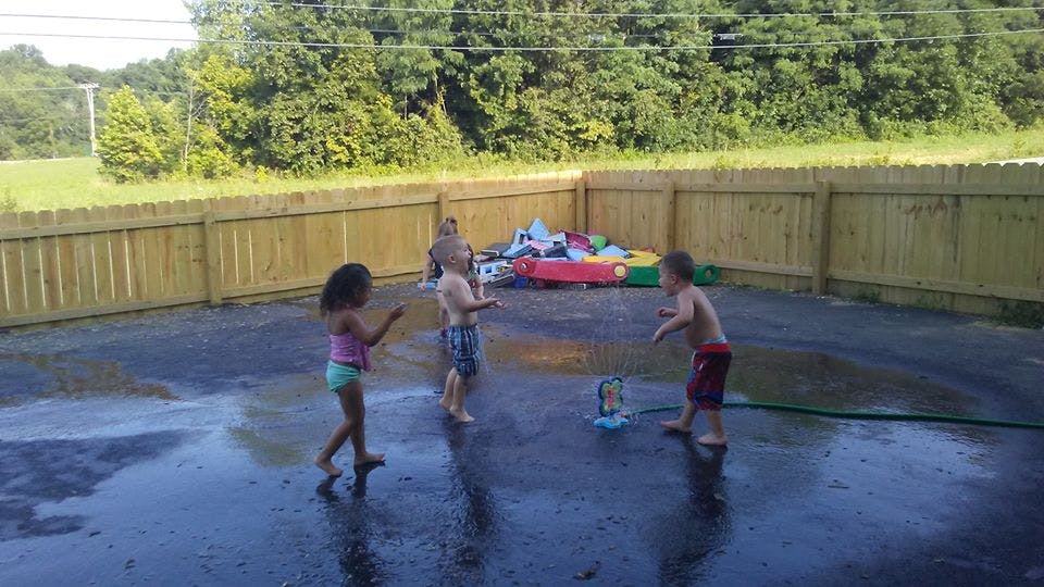 Children playing with water in a paved area