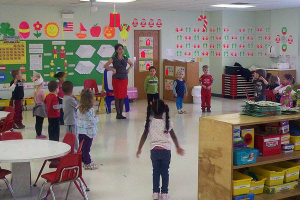Adult and children standing in a classroom