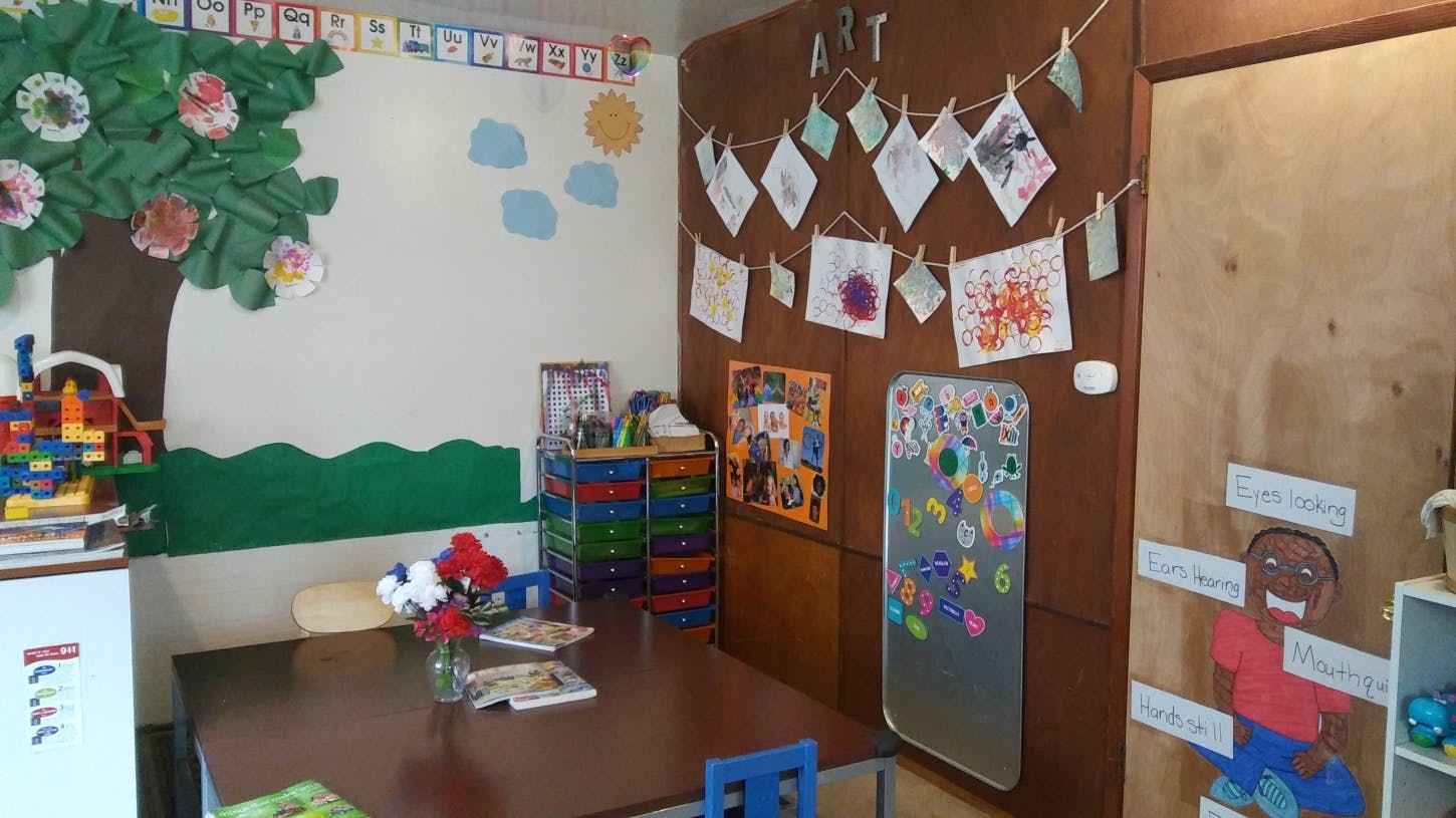 Classroom with a table, wall decorations, and children's artwork
