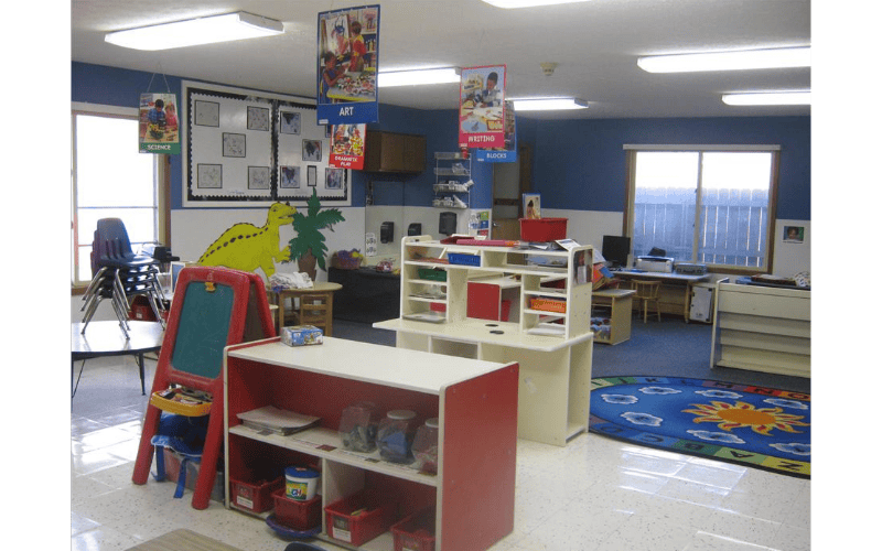 An empty classroom with various learning stations and brightly colored decorations