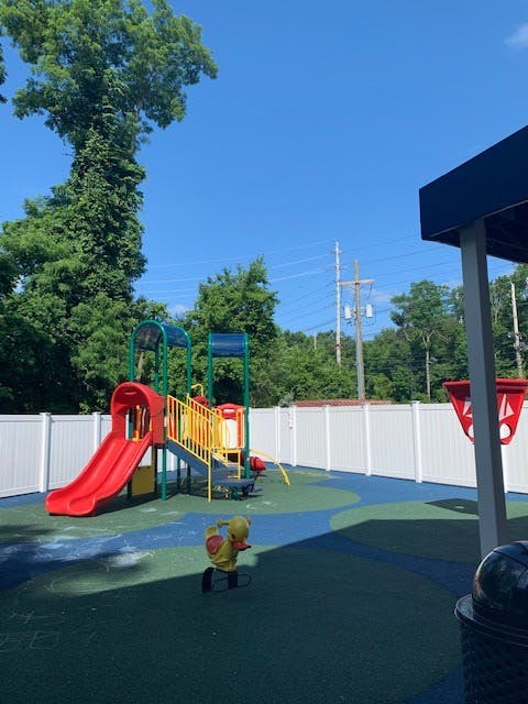 Playground with a red slide, yellow stairs, and a spring rider