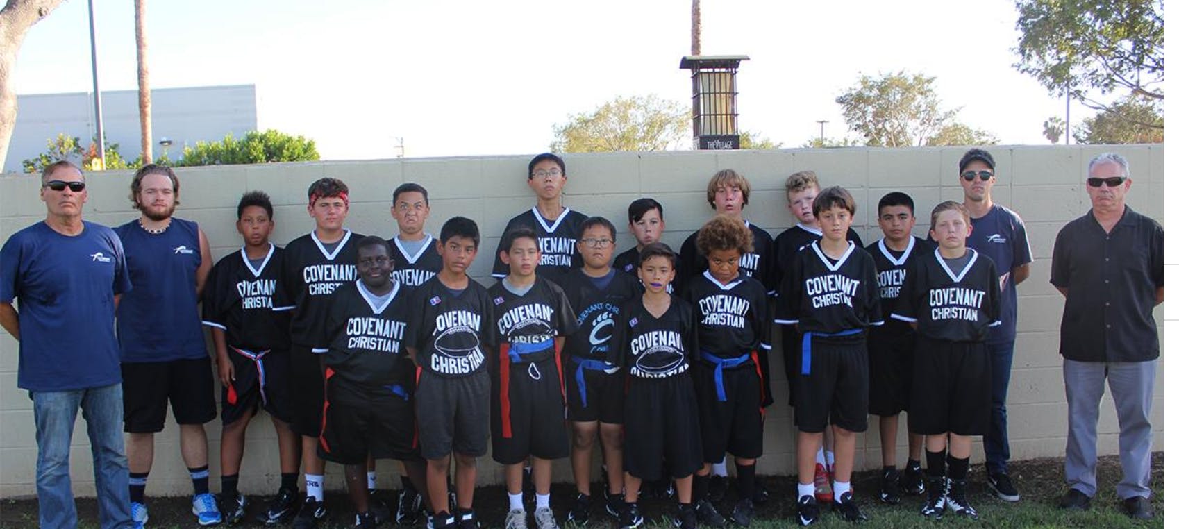 Group of adults and children in sports uniforms standing together