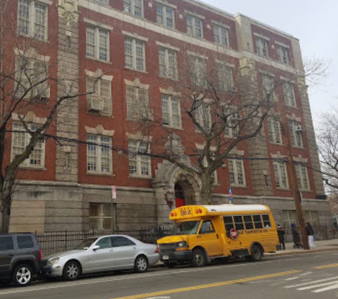School bus parked in front of a large brick building