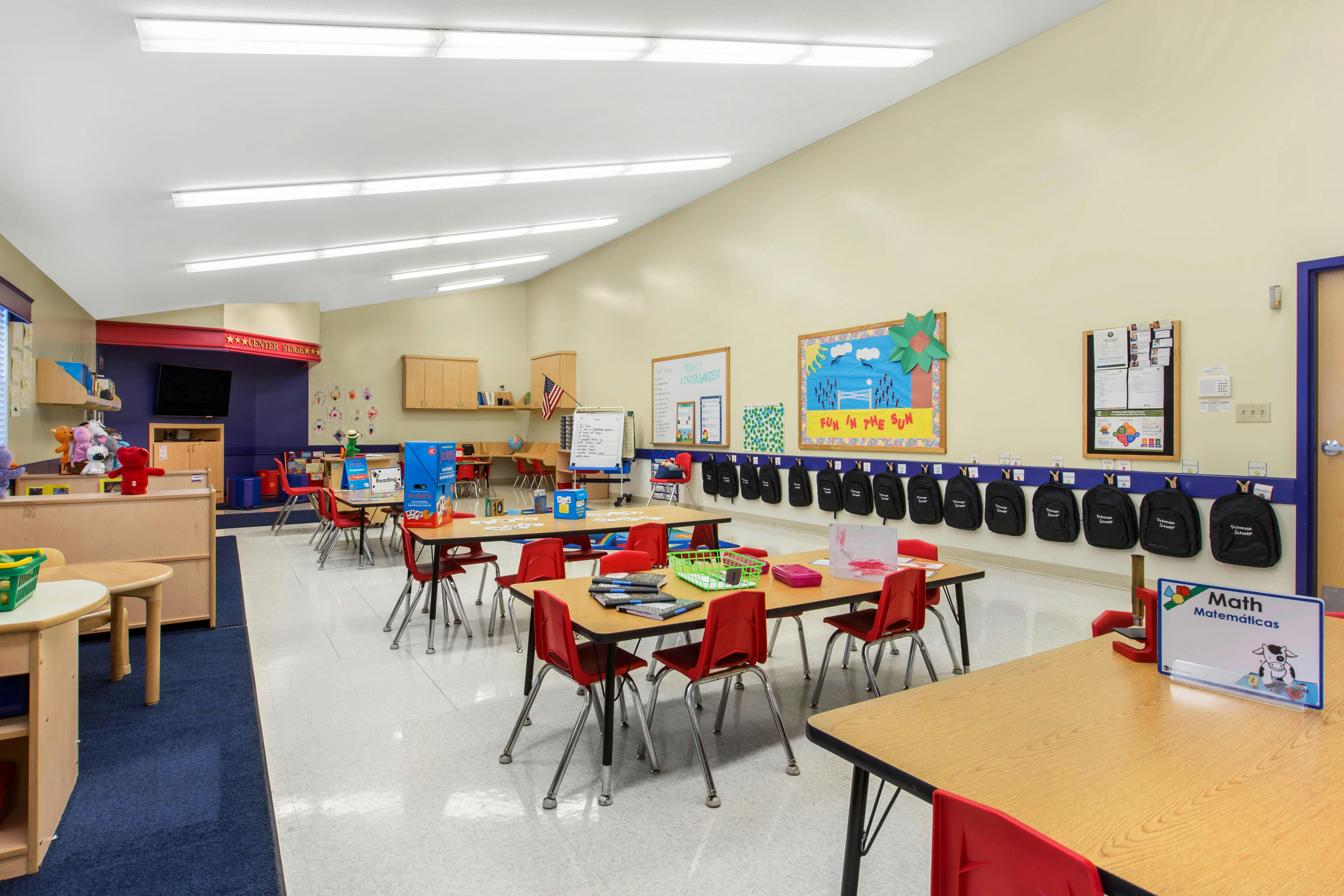 Classroom with small tables and chairs, whiteboards, and a "FUN IN THE SUN" display