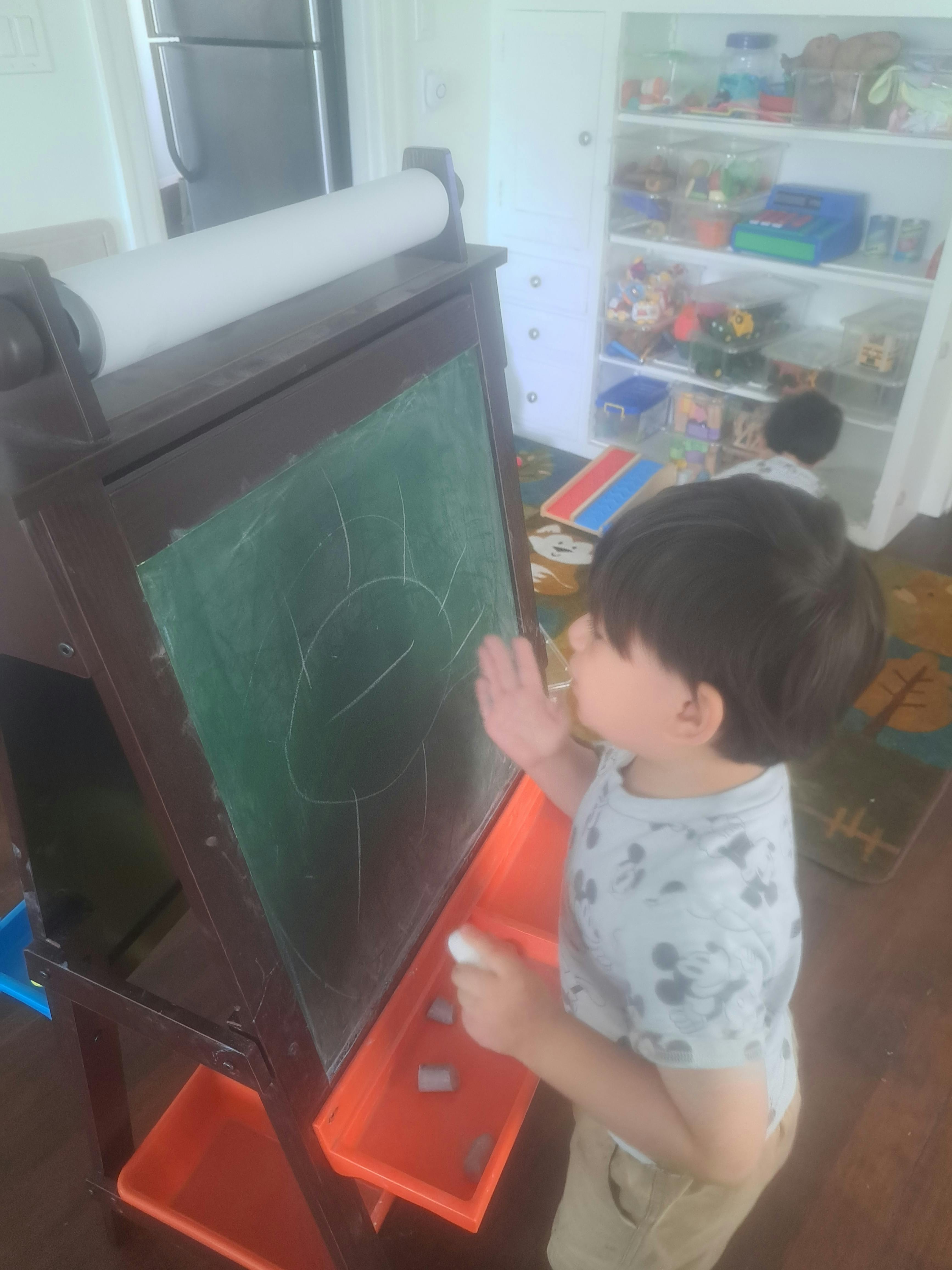 Child drawing on a chalkboard