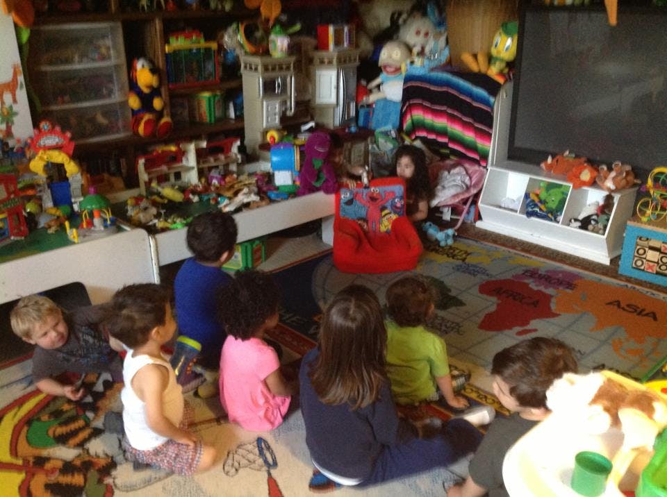 Children sitting on a rug in a playroom