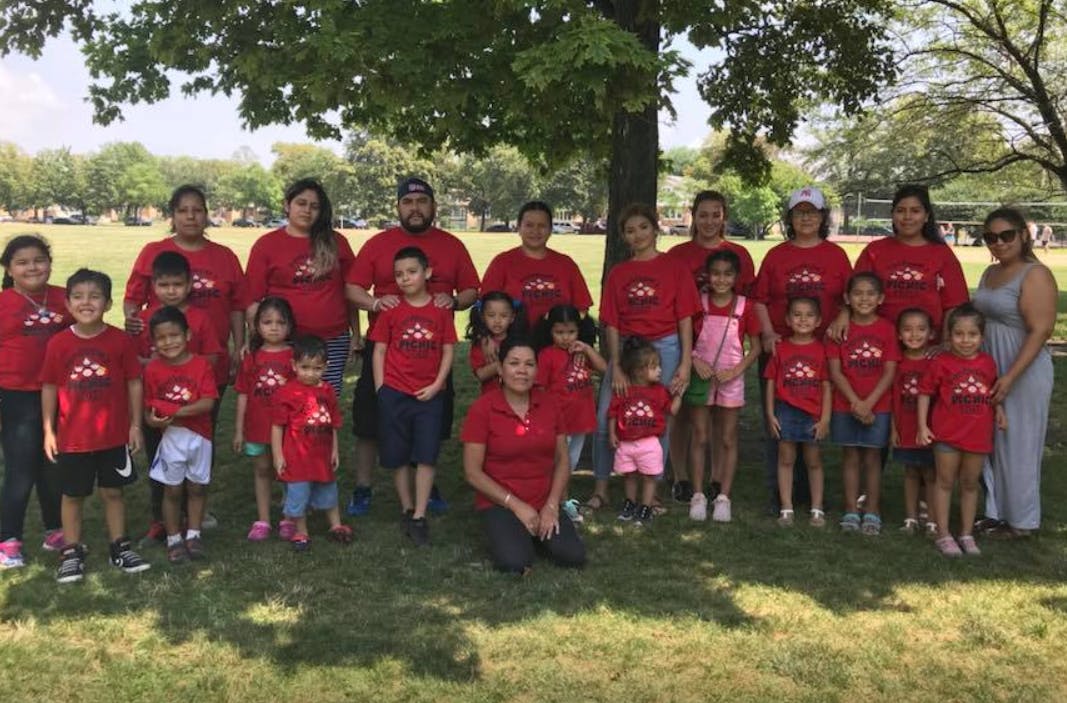 Group of people and children in red shirts posing outdoors