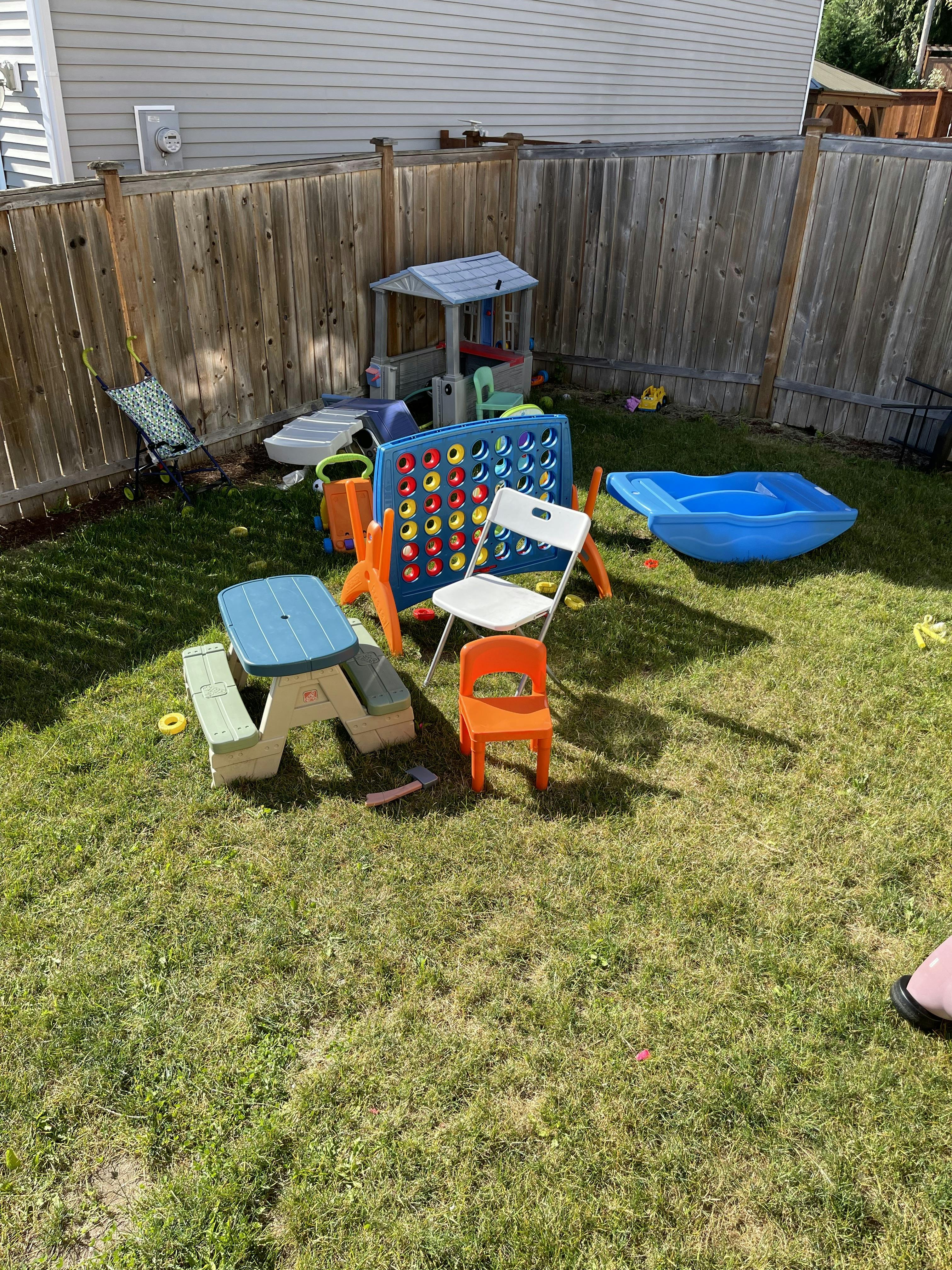 Plastic outdoor children's play equipment in a grassy backyard