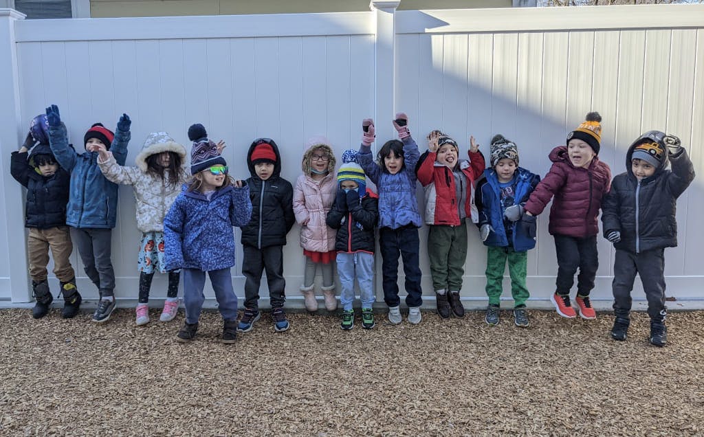 Group of children in winter coats and hats standing outdoors