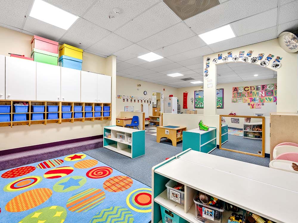 Colorful playroom or classroom with a rug, cubbies, and various furniture