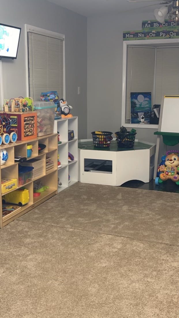 Playroom with shelves of toys, a small table, and a television