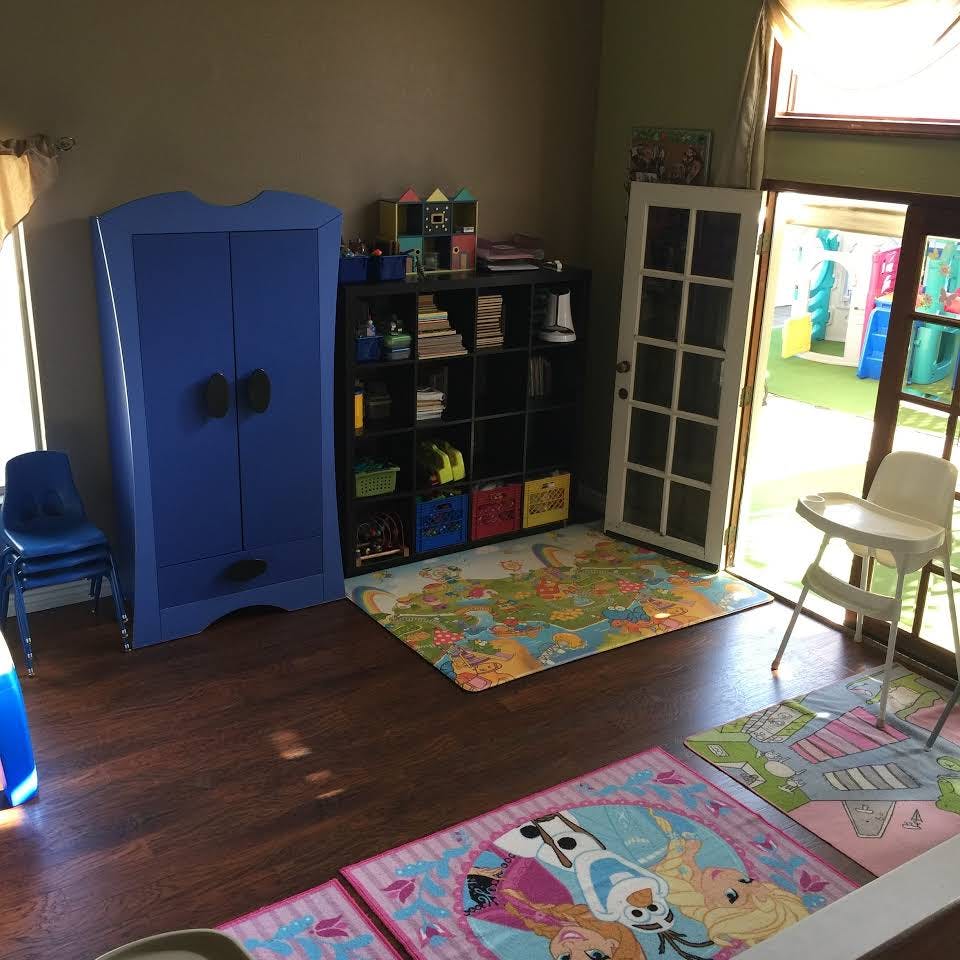 Playroom with blue cabinet, storage shelf, and colorful rugs