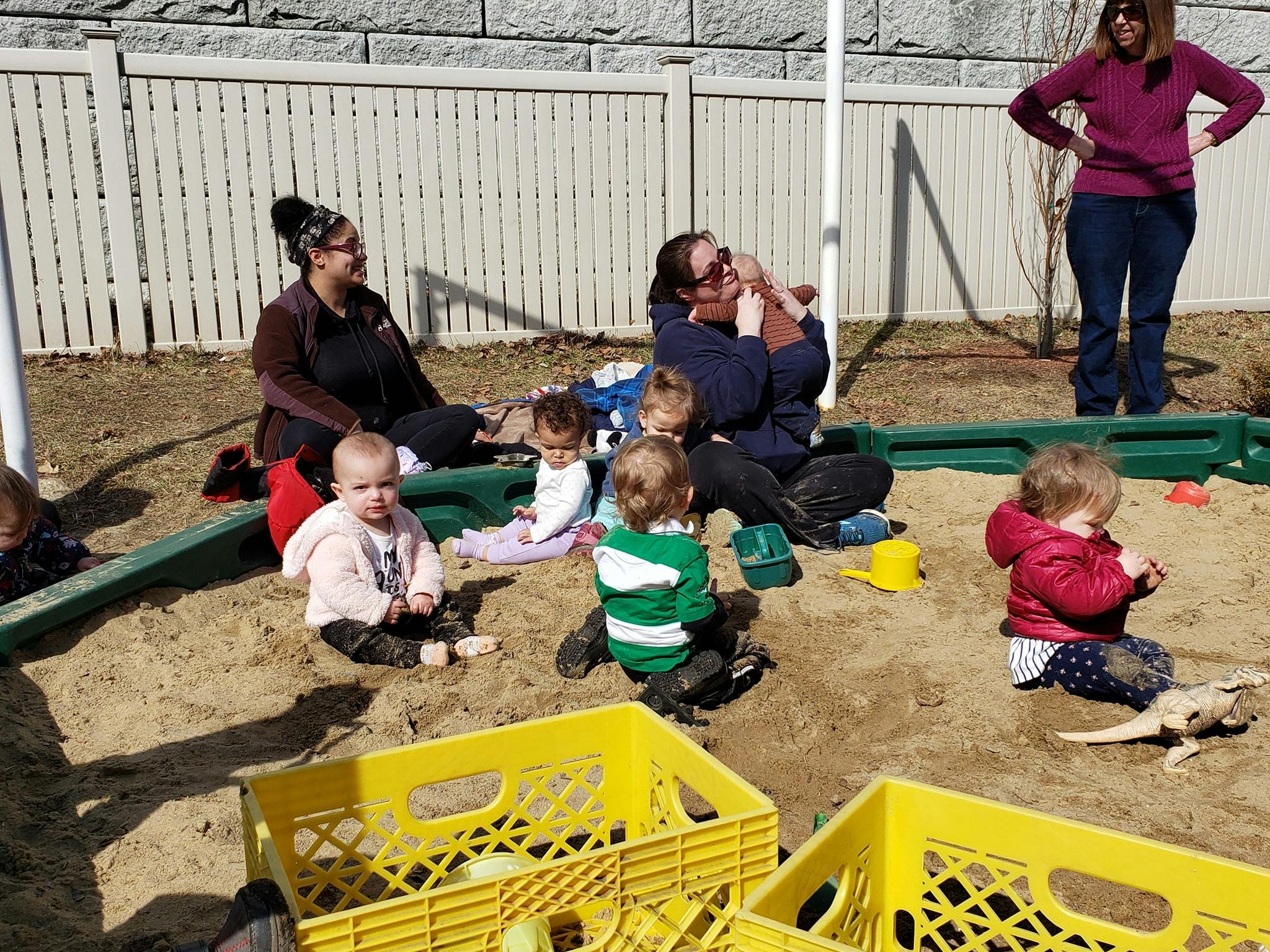 Adults and children playing in a sandbox
