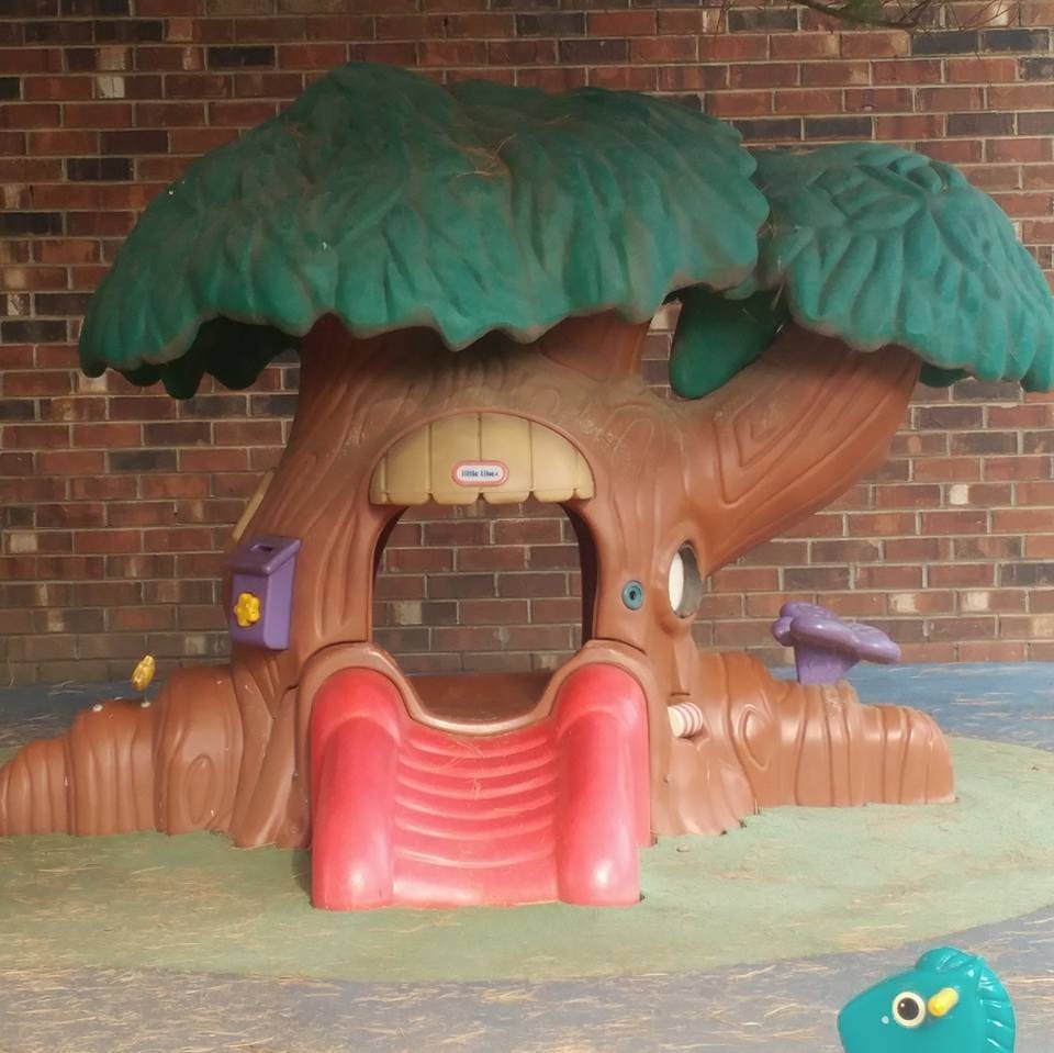 Tree-shaped playhouse with a red slide