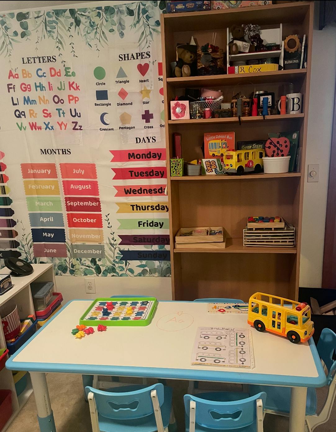 Children's classroom with alphabet chart, bookshelf, and small table with chairs
