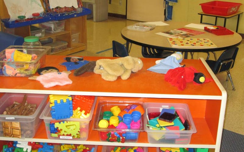 An orange shelf unit with various toys and supplies in a classroom setting
