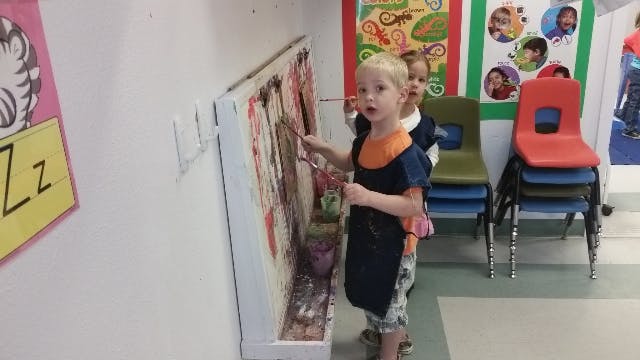 Child painting on an easel
