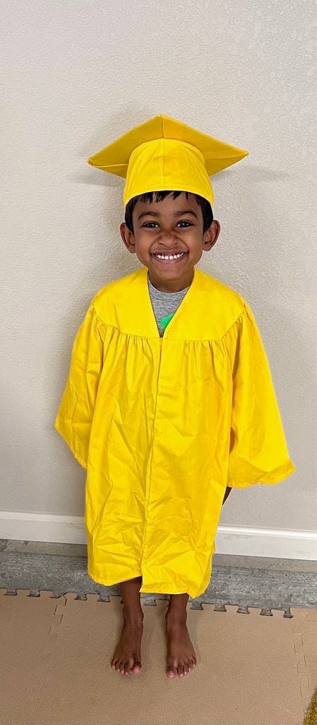 Child in a yellow graduation cap and gown