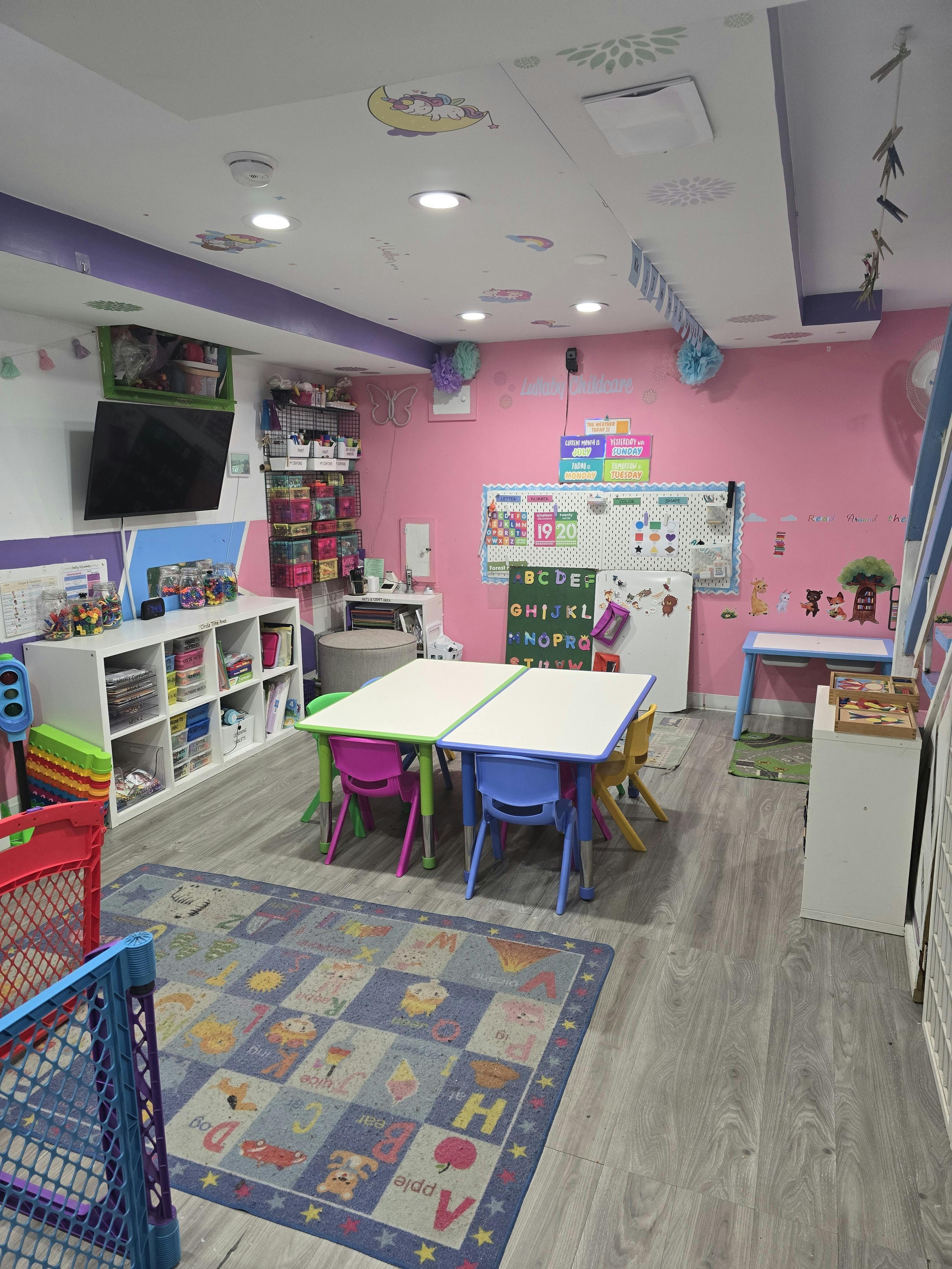 Children's classroom with tables, chairs, and an alphabet rug