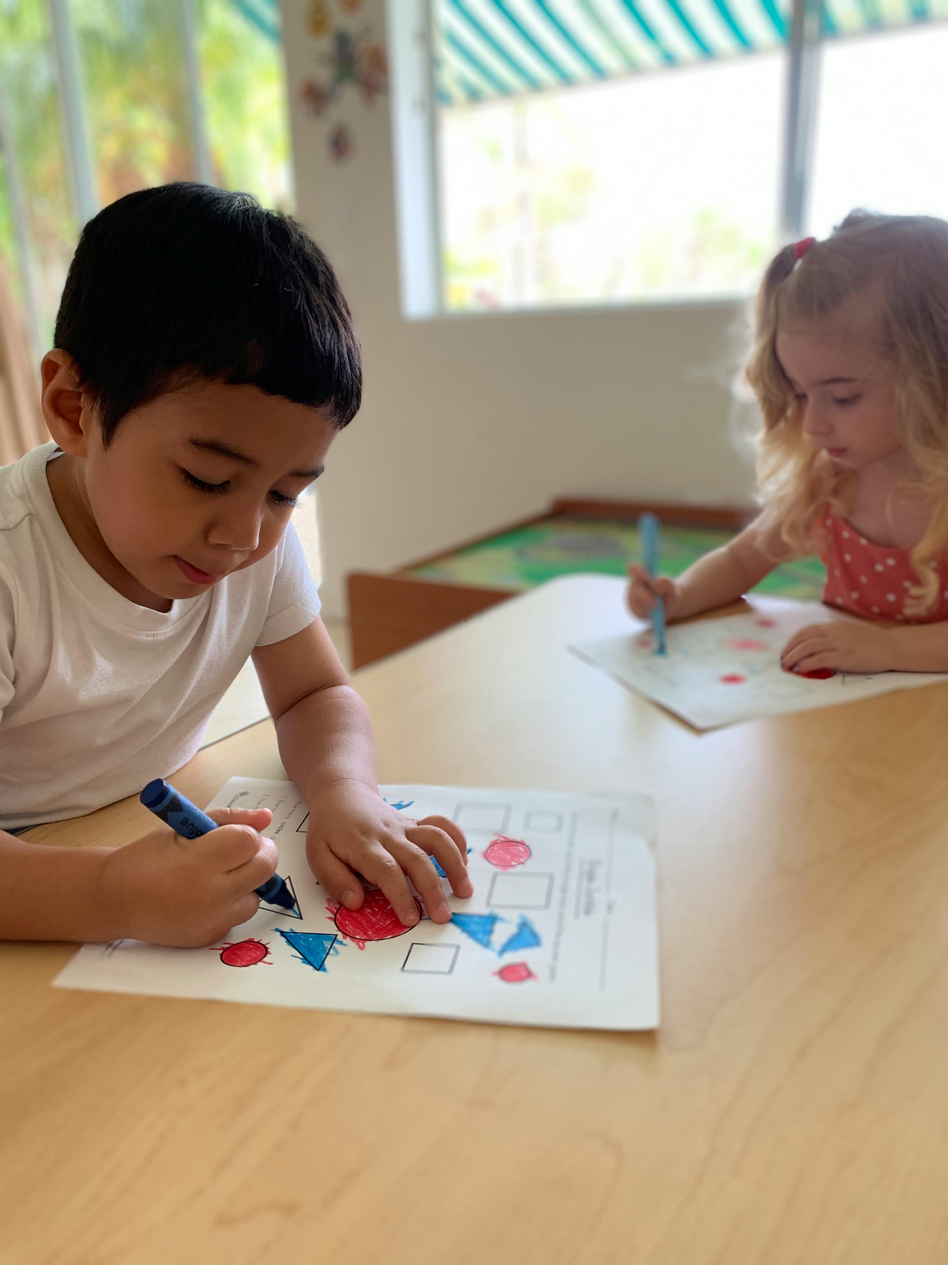 Two children coloring at a table