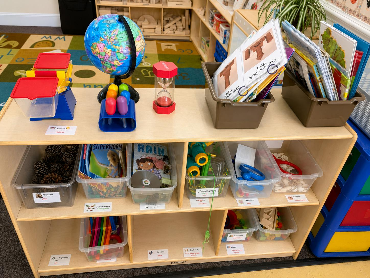 Classroom shelf with educational toys, books, globe, and labeled storage bins