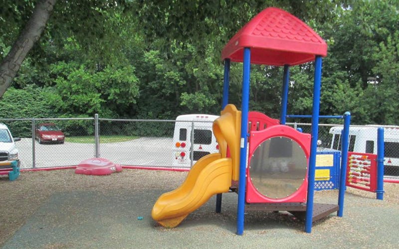 Colorful playground structure with a yellow slide and red roof