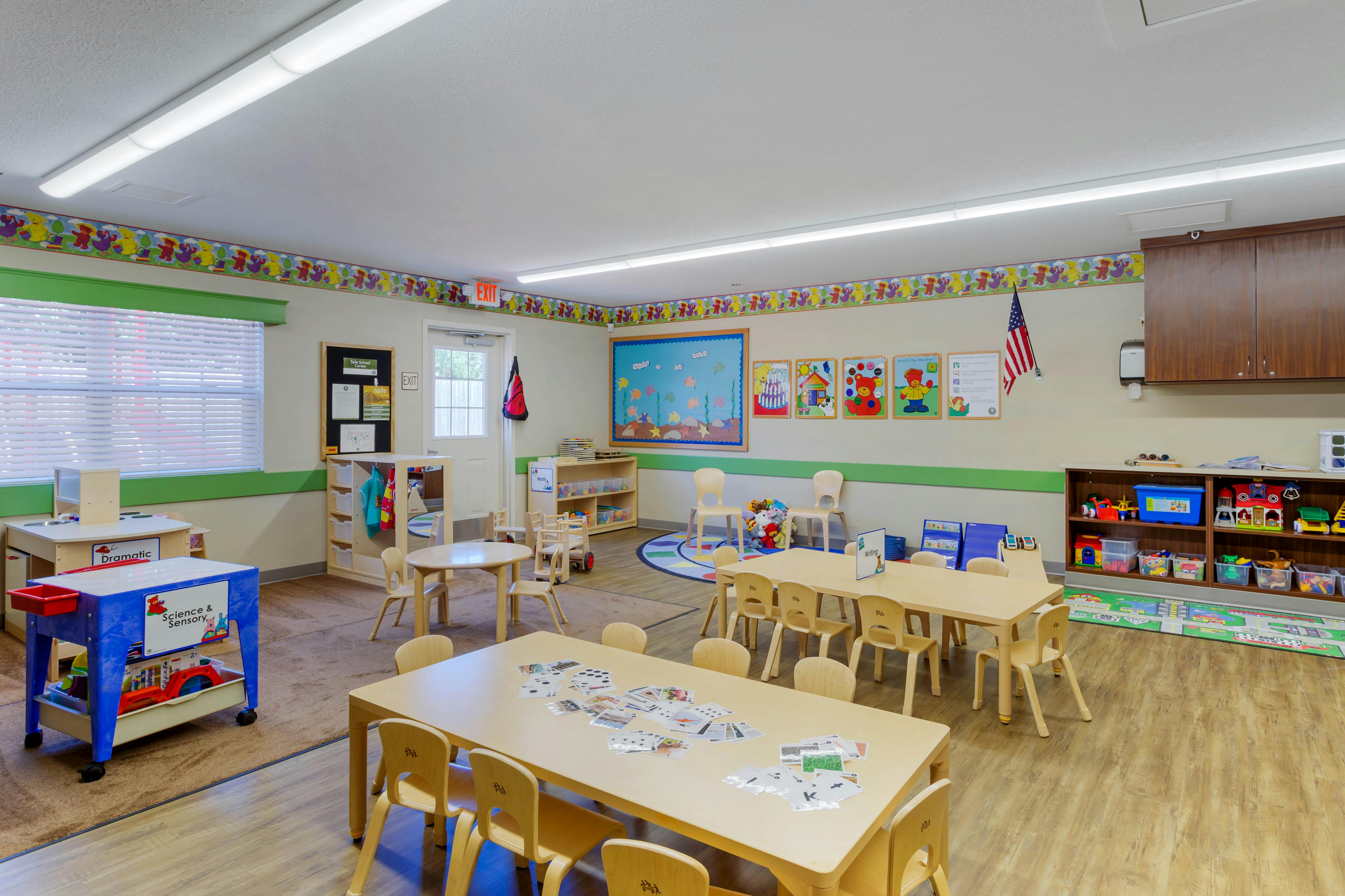 Classroom with small tables, chairs, and learning stations