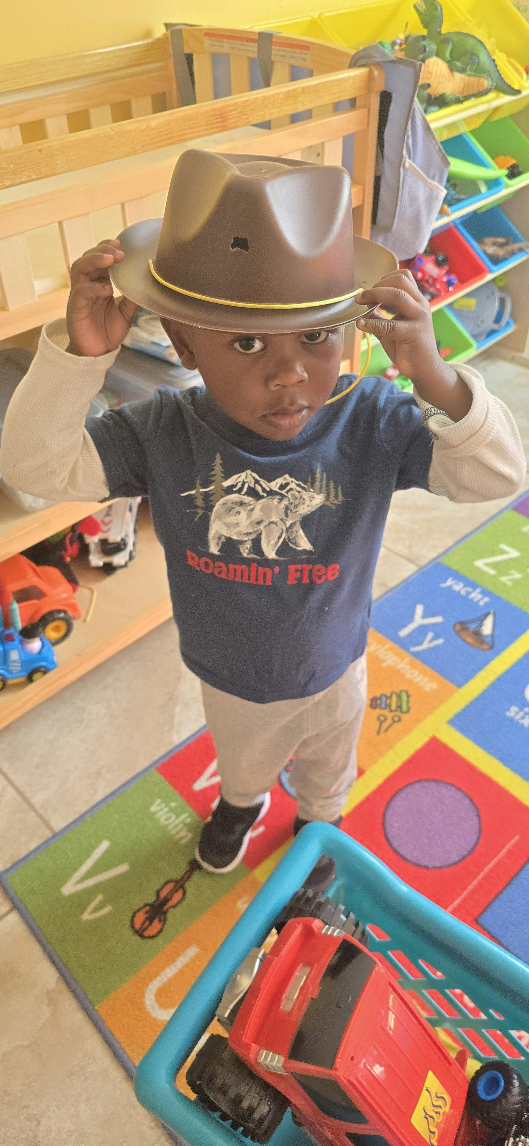Child in a cowboy hat in a playroom