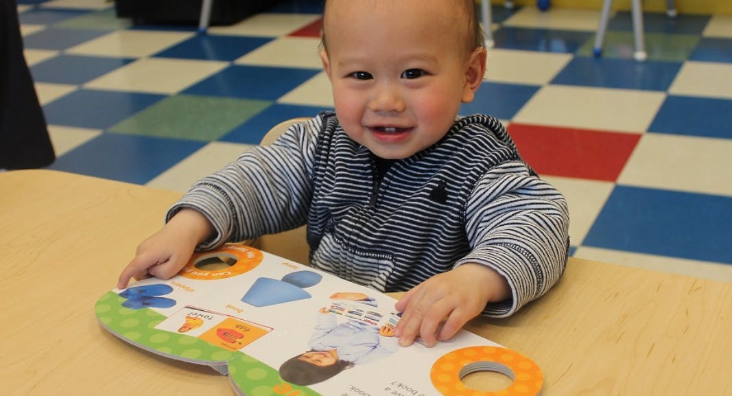 Child sitting at a table with a book