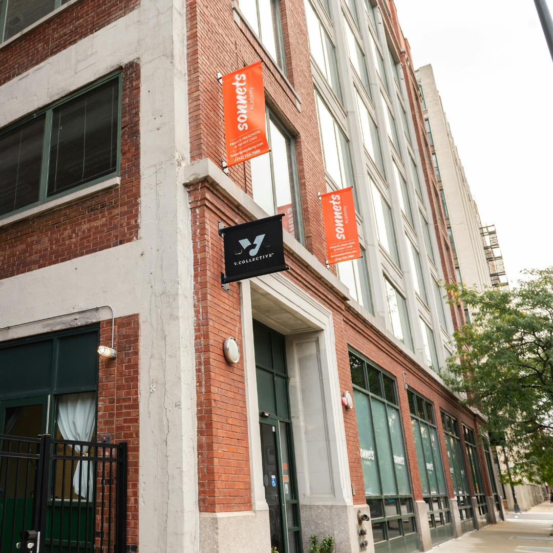 Brick building with banners that say "Sommets" and a black sign with a logo