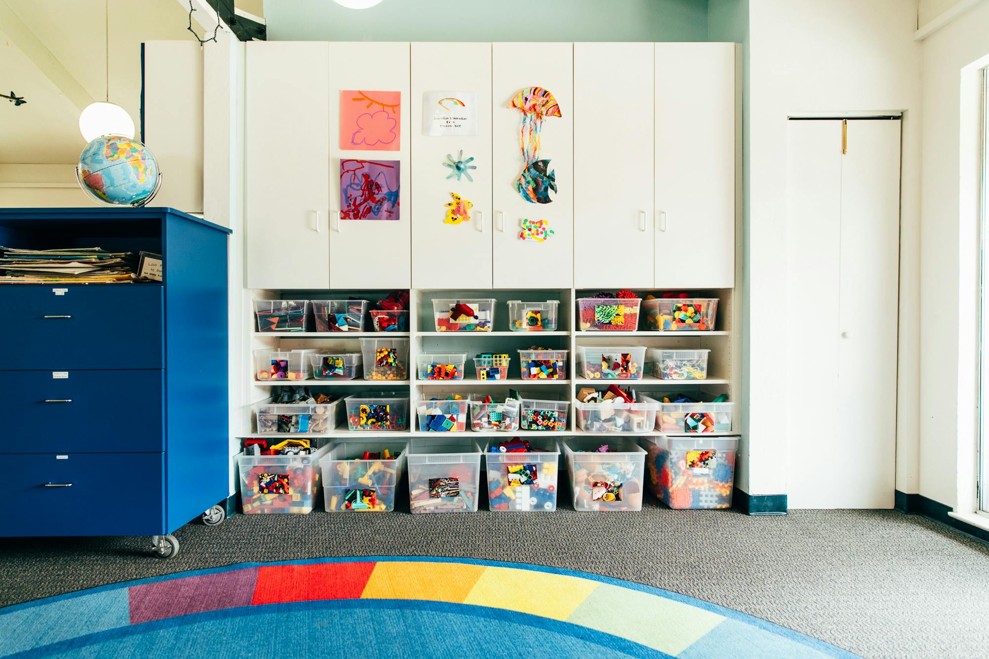 Classroom with shelves of toys and a blue cabinet