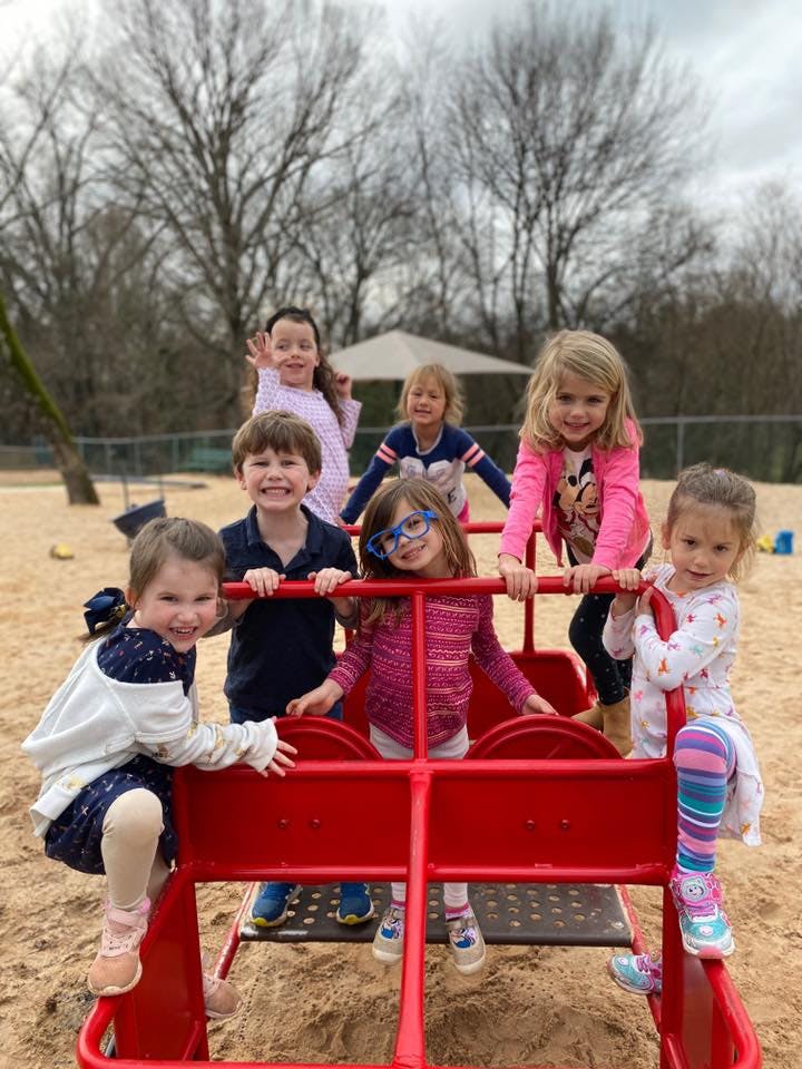 Group of children playing on a red playground structure