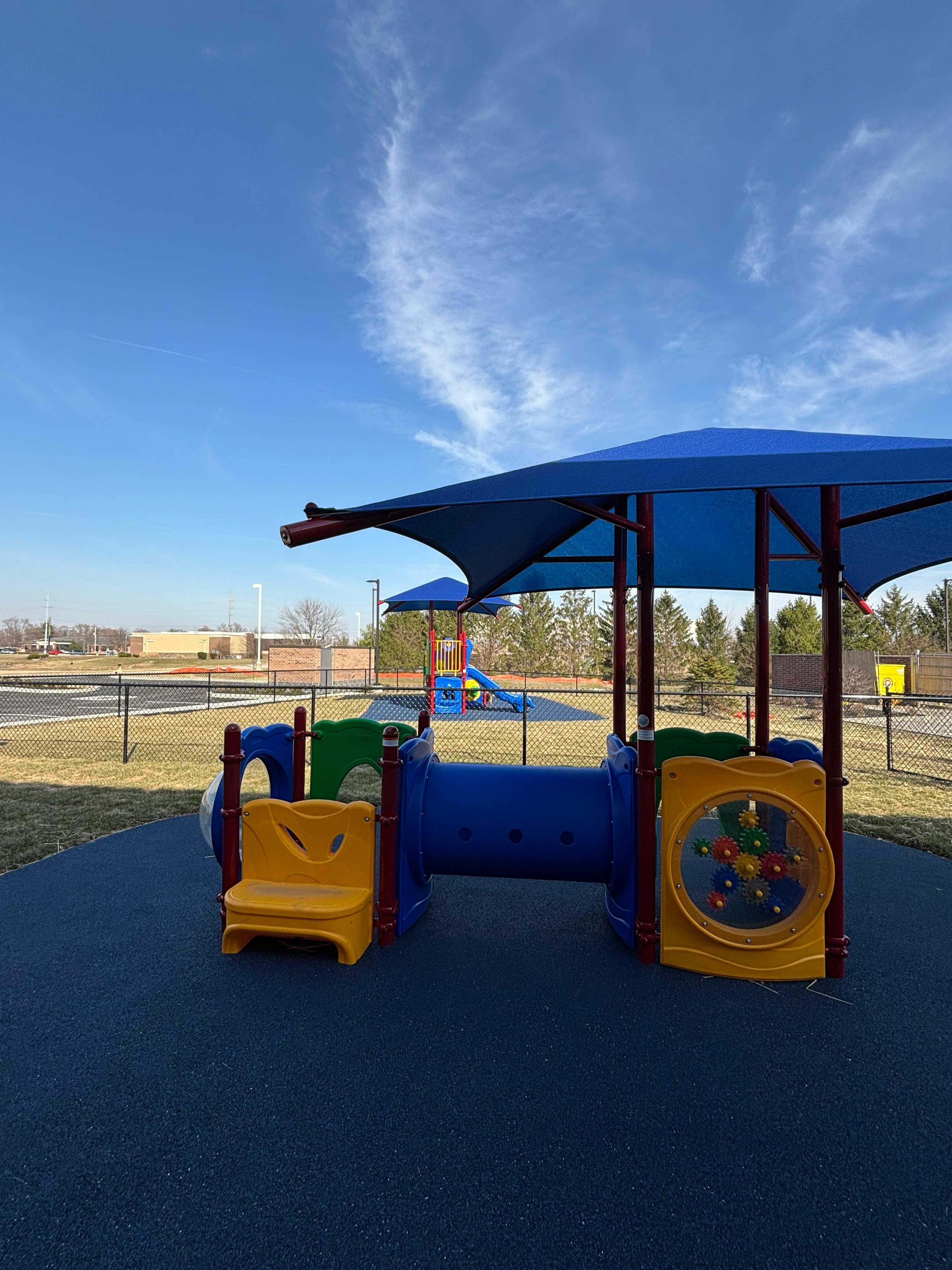 Playground with blue shade structure and colorful play equipment