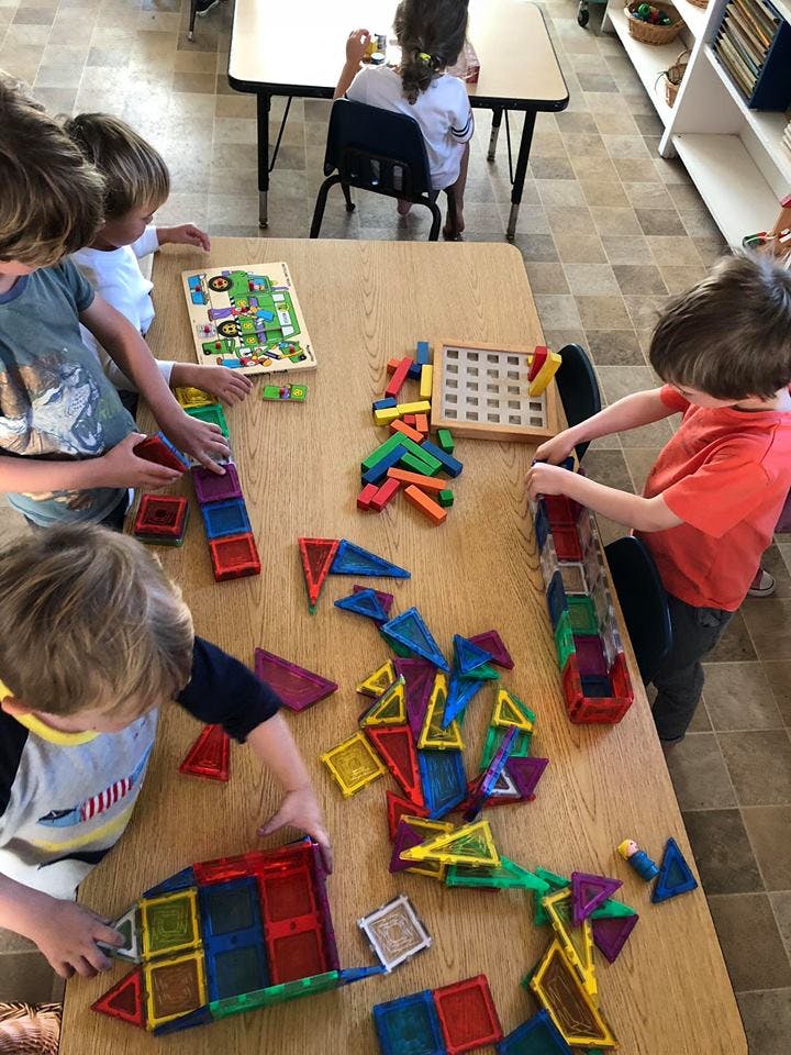 Children playing with colorful building blocks and puzzles at a table