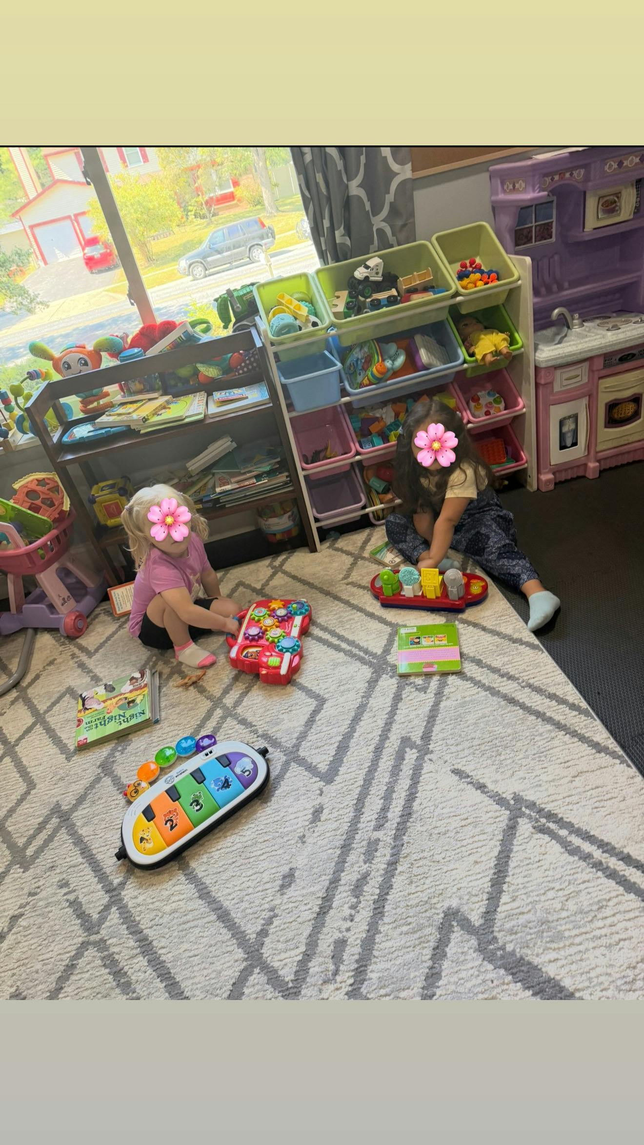 two children playing with toys on a rug in a play area