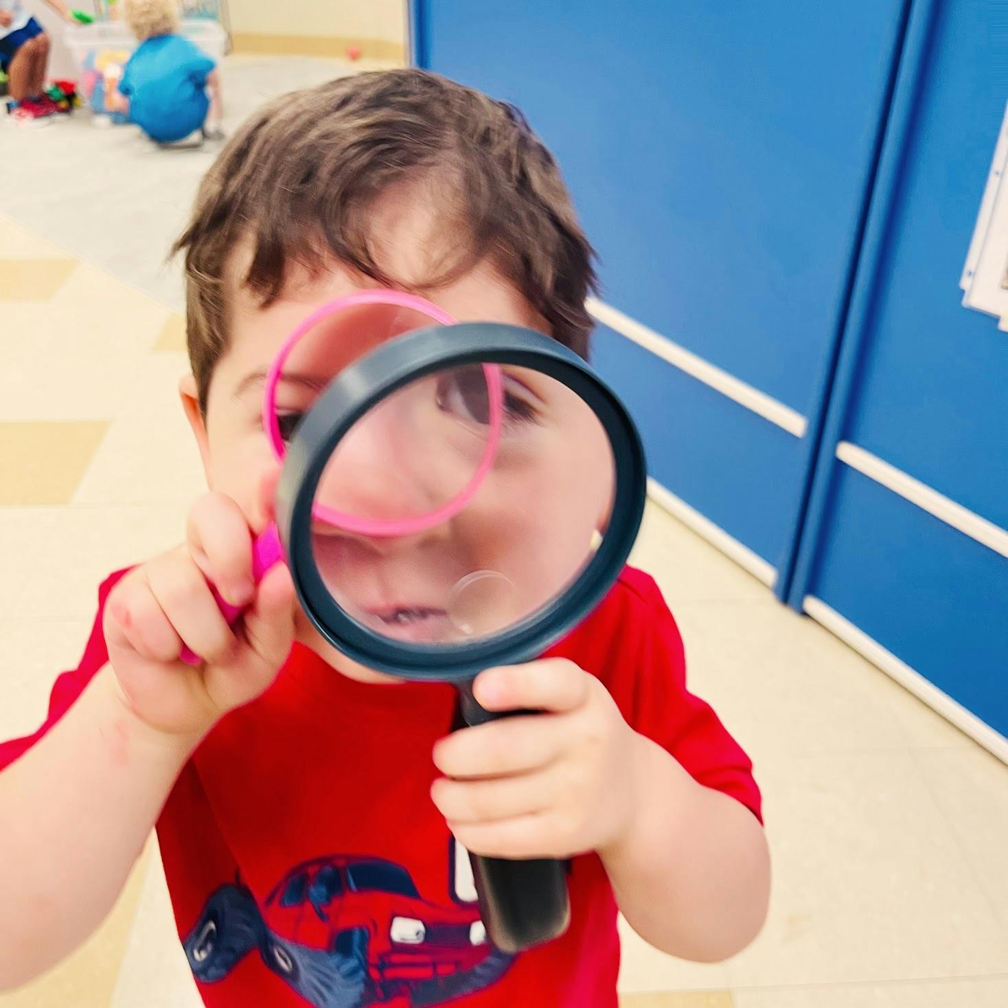 Child looking through a magnifying glass