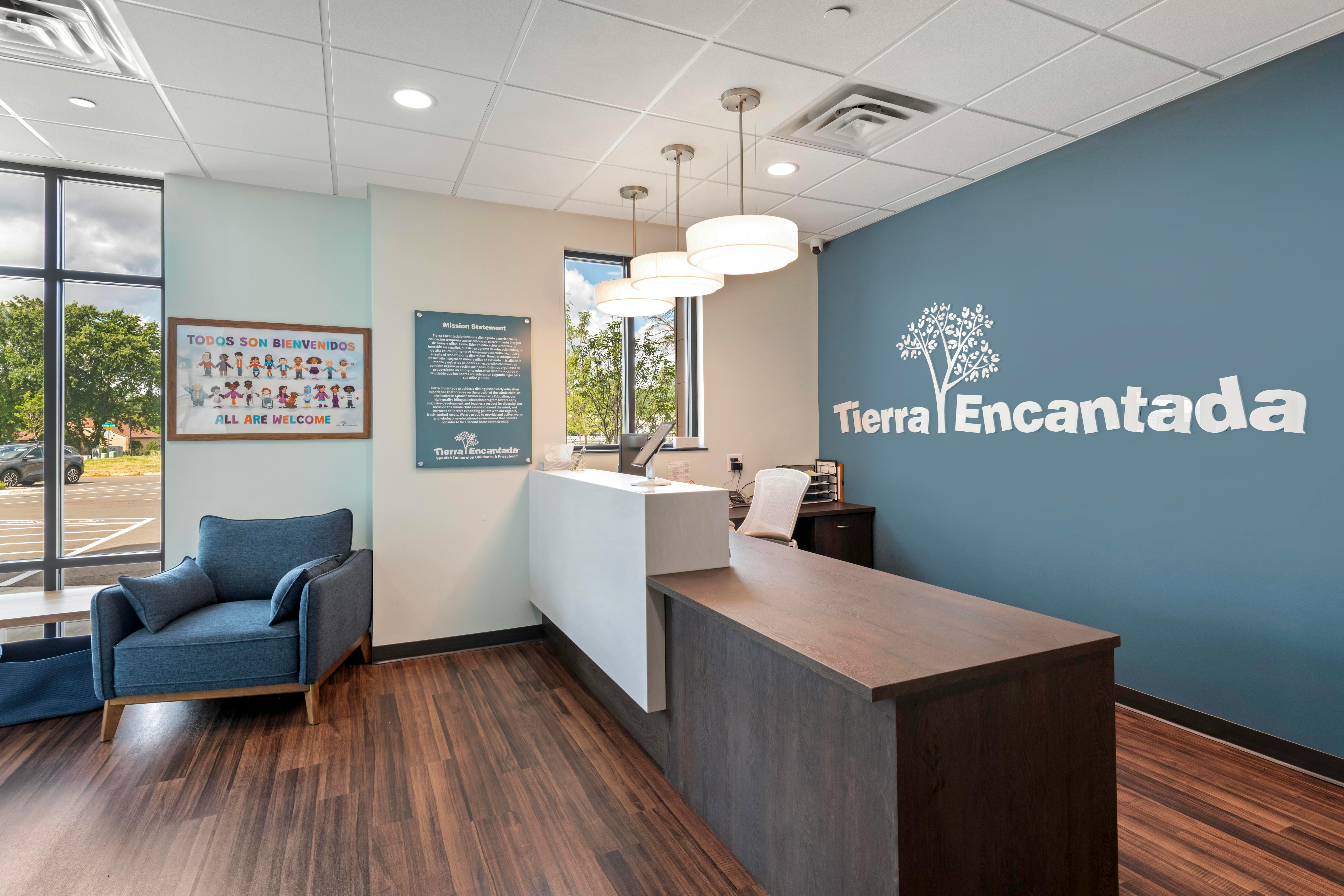 Reception desk and waiting area with a sign that reads "ALL ARE WELCOME"