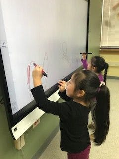Child drawing on an interactive whiteboard